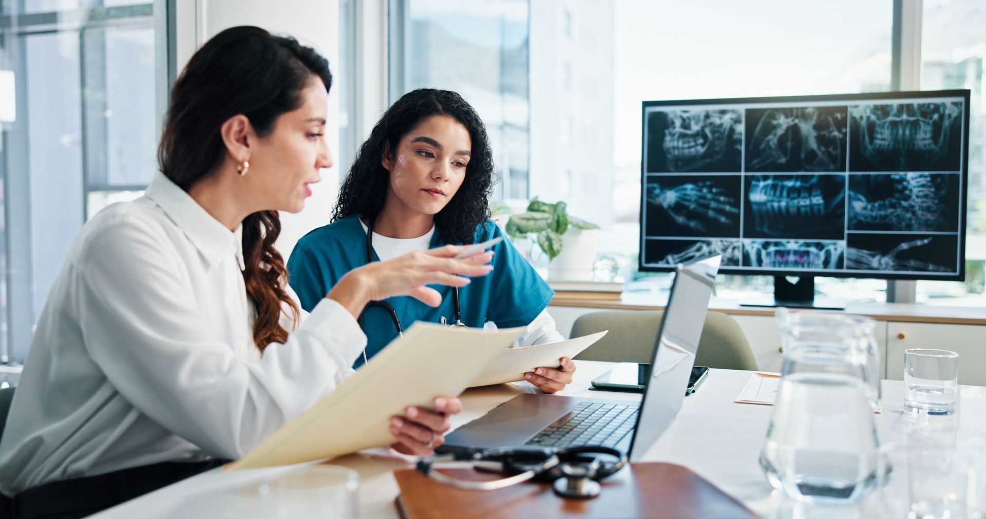 Two nurses reviewing coverage together at a workstation